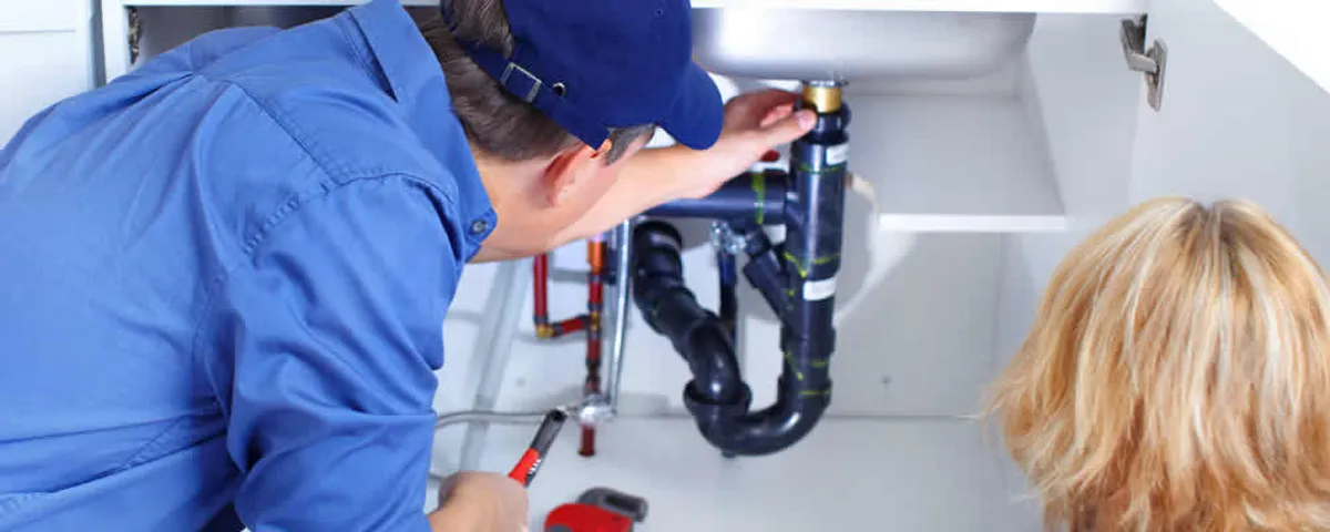Plumber repairing under-sink drain pipes and fittings in Easton, PA